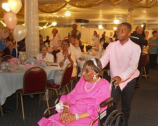 William D. Lewis The Vindicator Rev. Flonerra Henry-Harris makes a grand entrance at the Mahoning Country Club where a 100th birthday party was held for her 6-21-19. She is escorted by one of er great grandsons Mekher Madison, 11, of Streetsboro.