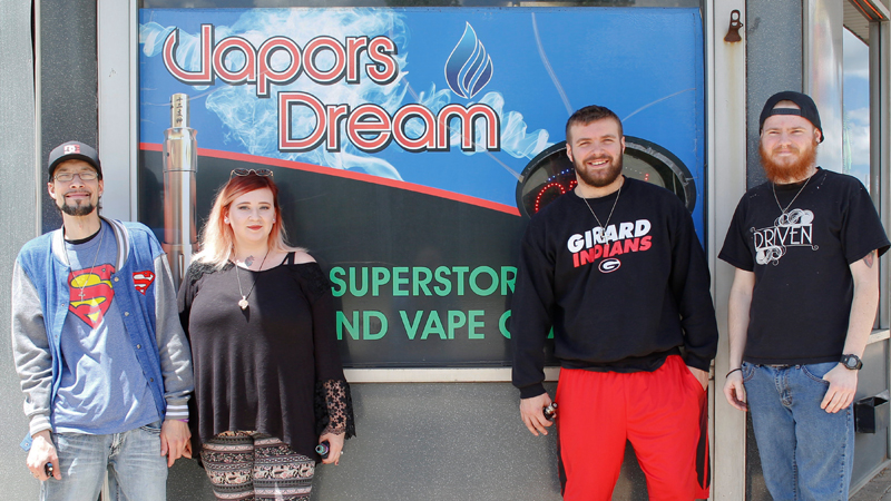 Vapors Dream employees in Girard, from left, Andrew Petrarca of Niles, Alana Carkido of Girard, Chris Vince of Girard and Isaiah Hathaway of Hubbard, stand outside the shop Friday afternoon. Girard and Youngstown are considering Tobacco 21 legislation to raise the legal age limit to 21 to buy tobacco or vape products. 