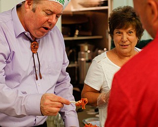 Thomas G. Welsh Jr., serves Keith LaMorticella some of his bulgogi, a Korean barbecue, while Sally Joseph, who was serving some of her baked macaroni, stands by during Taste of St. Patrick's at St. Patrick Church of Youngstown on Sunday. EMILY MATTHEWS | THE VINDICATOR