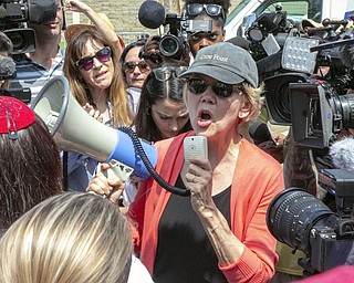 Democratic presidential candidate Sen. Elizabeth Warren, D-Mass., speaks through a megaphone while surrounded by the media outside the Homestead Detention Center, where the U.S. is detaining migrant teens, in Homestead, Fla., Wednesday.