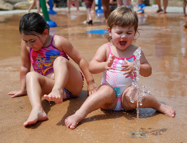 Sisters Scarlett, 1, right, and Riley HIbbird, 4, of Boardman play in the water at the water park in the James L. Wick, Jr. Recreation Area in Mill Creek Park on Thursday. EMILY MATTHEWS | THE VINDICATOR
