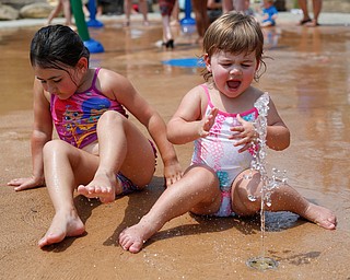 Sisters Scarlett, 1, right, and Riley HIbbird, 4, of Boardman play in the water at the water park in the James L. Wick, Jr. Recreation Area in Mill Creek Park on Thursday. EMILY MATTHEWS | THE VINDICATOR