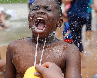 Mylen Cobb-Pippins, 9, who attends Daycare Storybook, gets sprayed with water at the water park in the James L. Wick, Jr. Recreation Area in Mill Creek Park on Thursday. The daycare went to the park today to cool off and enjoy the weather. EMILY MATTHEWS | THE VINDICATOR