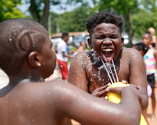 Michael Cobb-Pippins, 12, right, gets sprayed with water by his brother Mylen Cobb-Pippins, 9, both of whom attend Daycare Storybook, gets sprayed with water at the water park in the James L. Wick, Jr. Recreation Area in Mill Creek Park on Thursday. The daycare went to the park today to cool off and enjoy the weather. EMILY MATTHEWS | THE VINDICATOR