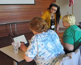 Neighbors | Jessica Harker.Librarian Hannah Matulek helped community members design puzzles using Microsoft Word to be engraved on to wood May 11.