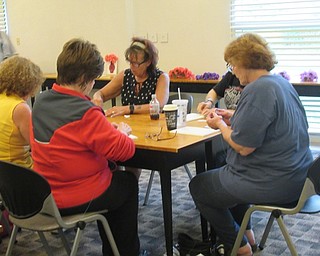 Neighbors | Jessica Harker .Community members wrapped string around nails in a piece of wood to create a vase shape at the Austintown library's craft night on May 6.