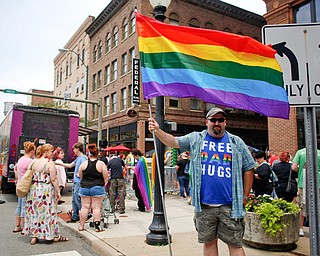 Michael Amedio, of East Liverpool, holds a pride flag and wears a shirt that reads Free Dad Hugs at the 11th annual Pride parade and festival in downtown Youngstown on Saturday afternoon. Amedio said he wore the shirt as a message of support that some people in the LGBTQ do not receive from their parents. EMILY MATTHEWS | THE VINDICATOR