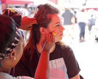 Krystal Adams, of Austintown, gets her face painted by Terri Belser, of Terri's Face Painting, at the 11th annual Pride parade and festival in downtown Youngstown on Saturday afternoon. EMILY MATTHEWS | THE VINDICATOR