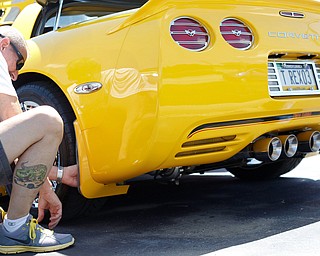 Rex Swortzbeck, of Greenville, Pa., puts a chrome plate behind one of the wheels of his 2003 Chevrolet Corvette at the Mahoning Valley Corvette Club's 25th Annual Corvette and Steel Car Show at Greenwood Chevrolet in Austintown on Sunday. EMILY MATTHEWS | THE VINDICATOR