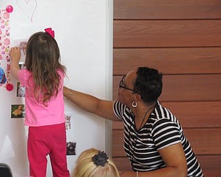 Children's librarian Rhonda Monroe helped children match baby animals with their moms at the Tea-Riffic Moms event.