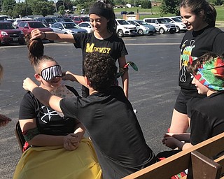 Neighbors | Jessica Harker.Blind folded students had to try to put a bib on, and then feed  fellow student as part of a relay race organzied for eighth graders during St. Christine's annual Field Day event.