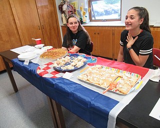 Neighbors | Jessica Harker.St. Christine's seventh grade students sat by tables full of food that they brought to the school's annual International Day May 23.