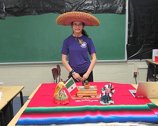 Neighbors | Jessica Harker.Delainey Blacsher dressed up for St. Christine's International Day May 23, posing next to her table decorated in celebration of her Mexican heritage.