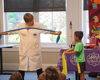 Neighbors | Jessica Harker .Tammy with Mad Science demonstrated how astronauts exercise in space to a volunteer at the Canfield library June 28.