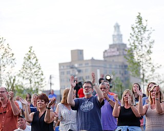 People in the crowd clap along as Earth, Wind & Fire perform at the Youngstown Foundation Amphitheatre Friday night. EMILY MATTHEWS | THE VINDICATOR