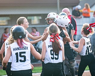 DIANNA OATRIDGE | THE VINDICATOR  Canfield's Riley Billack is mobbed by her teammates at home plate after hitting a home run against Howland during the 10U tournament in Boardman on Friday.