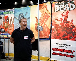 Arthur Suydam, one of the artists for The Walking Dead, talks to visitors at the Youngstown Comic Con in Covelli Centre on Saturday afternoon. EMILY MATTHEWS | THE VINDICATOR