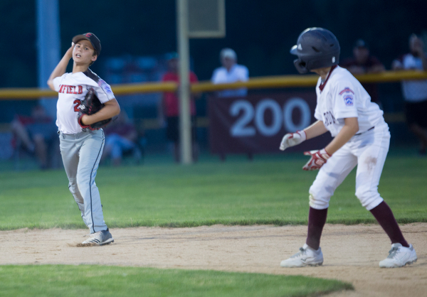 Canfield's Jake Bednar gets ready to throw the ball to first while Boardman's Rowan Urbach watches and waits to advance to third during their game at Field of Dreams in Boardman on Wednesday night.