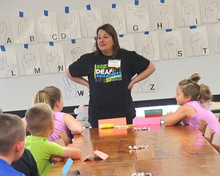 Neighbors | Jessica Harker .Librarian Karen Steed discussed deaf language and culture with children gathered at the Poland library June 23.