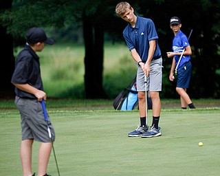 Caleb Domitrovich, 14, of McDonald, center, putts the ball while Matthew Morelli, 13, of New Castle, right, and C.J. Brew, 12, of Hubbard, watch during the Greatest Golfer junior qualifier at Tam O'Shanter Golf Course in Hermitage, Pa. on Thursday. EMILY MATTHEWS | THE VINDICATOR