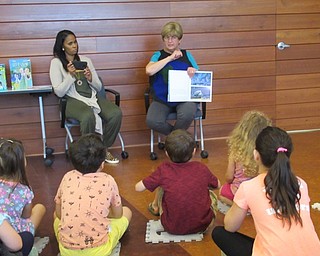 Neighbors | Jessica Harker .Green Team member Peggy Flynn read "Dear Children of Earth" to children gathered at the Michael Kusalaba library June 13.