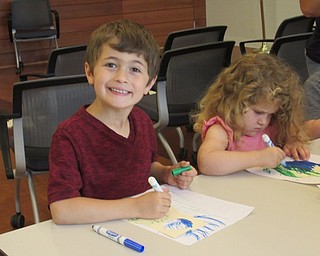 Neighbors | Jessica Harker .Children worked to color the earth onto door hangers June 13 at the Michael Kusalaba library's event hosted by the Green Team.