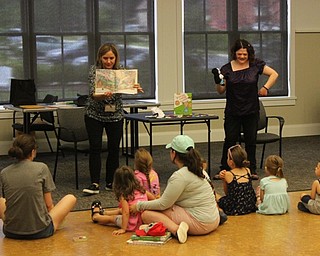 Neighbors | Abby Slanker.Amanda Kollar (right), assistant supervisor, youth librarian, animated "If You Give a Cat a Cupcake," with a puppet show while Lyndsay Cramer (left), children's librarian, read the book at the Canfield library.