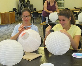 Neighbors | Jessica Harker.Community members used acrylic paint to decorate paper lanterns with a space theme at the Austintown library's Galaxy Lantern making event July 8.
