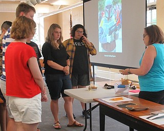 Neighbors | Jessica Harker .Librarian Renee Beverly instructed teenagers in how to use different materials to construct pieces of cosplay armor July 9 at the Poland library.