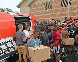  ROBERT K.YOSAY  | THE VINDICATOR..Cleveland Browns officials visited...Chaney High School - girard.. and one other school to make a donation to the CowboysÕ football and ..Chaney football  team members carry boxes of equipment from the van...
