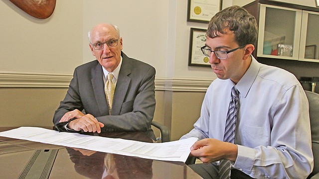 Mahoning County Auditor Ralph Meacham and staff accountant Alex Mangie review a spreadsheet that summarizes financial statistics for all 14 public school districts in Mahoning County.
