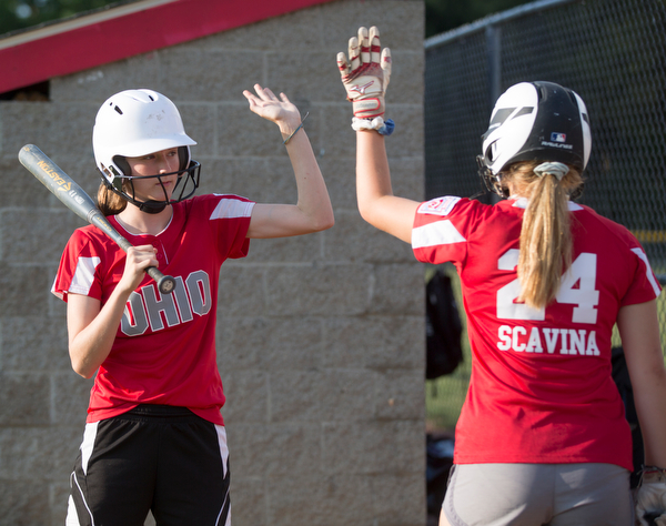 Emily Denney, left, and Alaina Scavina high-five as they practice with their Canfield-Poland softball team, who will be playing in the Junior League Softball World Series in Washington on Sunday. EMILY MATTHEWS | THE VINDICATOR