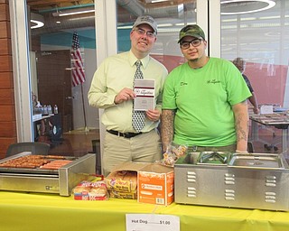 Neighbors | Jessica Harker .Chuck Parker and Dion Taylor from Cafe Augustine sold hot dogs at the Michael Kusalaba library on June 22 at the first Craft and Trunk Sale.