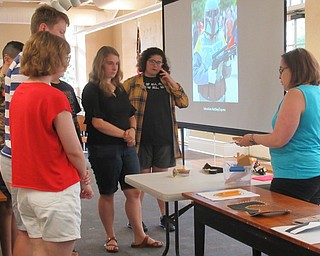 Neighbors | Jessica Harker .Librarian Annette Ahrens instructed teenagers in how to use different materials to construct pieces of cosplay armor July 9 at the Poland library.