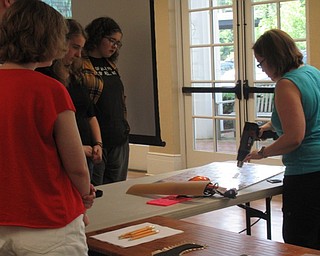 Neighbors | Jessica Harker .Using a heat gun Annette Ahrens showed teenagers at the Poland library how to work with Worbla, a thermo plastic used in construction of cosplay armor on July 9.