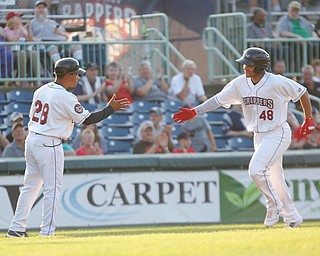 Scrappers' Yainer Diaz high fives manager Dennis Malave as he runs third after hitting a homerun during their game against the Spikes at Eastwood Field on Thursday night. EMILY MATTHEWS | THE VINDICATOR
