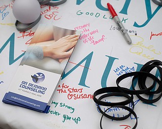 Pamphlets, bracelets, and stress balls are available at the New Day Recovery table at the Warren Walk Against Heroin at the Warren Amphitheater on Sunday. EMILY MATTHEWS | THE VINDICATOR