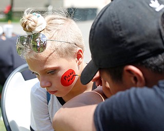 Destiny Carnes, 12, of Warren, gets the Pizza Hut logo painted on her face by Andrew Phan, a senior at Austintown Fitch High School and a volunteer with On Demand Drug Testing, at the Warren Walk Against Heroin at the Warren Amphitheater on Sunday. EMILY MATTHEWS | THE VINDICATOR