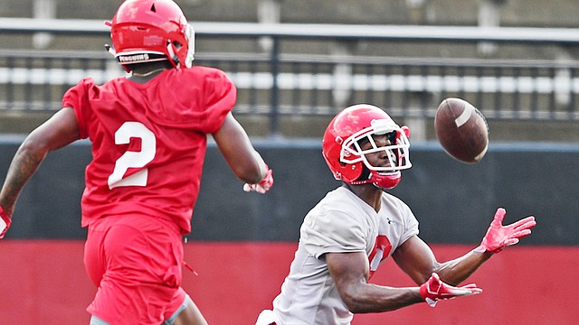 Youngstown State University's Samuel St. Surin, right, catches a pass while being covered by Devanere Crenshaw, during the team's practice Monday at Stambaugh Stadium.