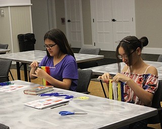 Neighbors | Abby Slanker.Valentina McKinley (left) of Poland and Samantha Serrano (right) of Austintown each created a stylish piece of art in a rainbow wall hanging at the Canfield library on June 24.