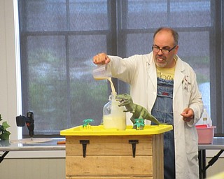 Neighbors | Jessica Harker .Dr. Cletus Beaker made a volcano explode, making the plastic dinosaurs "go extinct" at the Canfield library.