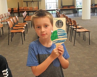 Neighbors | Jessica Harker .Joey Stidom, age 7, colored his door hanger provided by the Green Team July 16 at the Poland library.