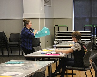 Neighbors | Abby Slanker.Adult Librarian Assistant Taylor Swan demonstrated how to make a hand-sewn pouch for electronicsat the Canfield library on July 24.
