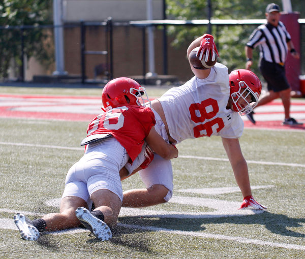 Patrick Minenok tackles Kyle Gregg during their scrimmage Saturday morning at Stambaugh Stadium. EMILY MATTHEWS | THE VINDICATOR