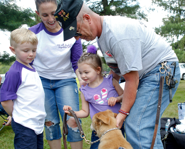 Harper Foley, 4, of Cortland, center, pets Gracy, the service dog of John Rossi, right, with her brother Emmett Foley, 6, and mother Jade Foley at the 41st annual Cars in the Park car show in Boardman Park on Sunday afternoon. Proceeds from the car show will go to Harper, who has Dravet Syndrome, a catastrophic form of epilepsy. EMILY MATTHEWS | THE VINDICATOR