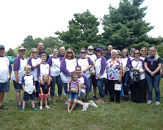 Jade Foley, of Cortland, front center, holds her daughter Harper Foley, 4, who has Dravet Syndrome, a catastrophic form of epilepsy, while family members and friends stand behind them at the 41st annual Cars in the Park car show in Boardman Park on Sunday afternoon. Proceeds from the car show will go to Harper. EMILY MATTHEWS | THE VINDICATOR