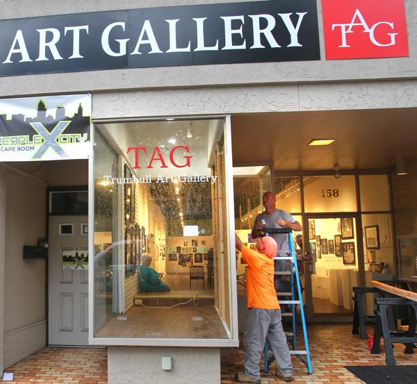 William D. Lewis the vindicator Workers from Warren Glass repair a window at TAG in Warren after a Tuesday afternoon storm blew out the window.