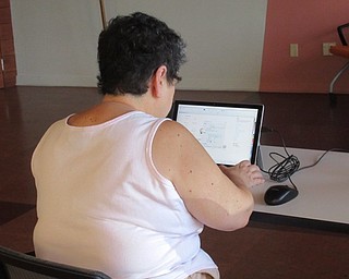 Neighbors | Jessica Harker .Community members worked on tablets to design their fourth of july themed patterns during the Fourth of July Engraved Glass event at the Michael Kusalaba library July 1.