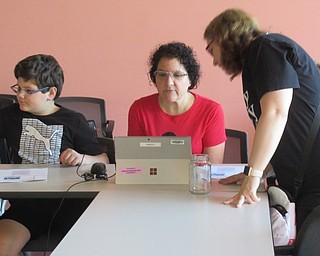 Neighbors | Jessica Harker .Librarian Samantha Schneider assisted community members in selecting from a number of patriotic designs to go on mason jar glasses July 1 at the Michael Kualaba library.