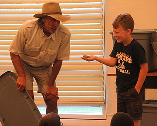 Neighbors | Jessica Harker .A volunteer named Parker held Jungle Terry's tree frog at his performance at the Austintown library July 10.